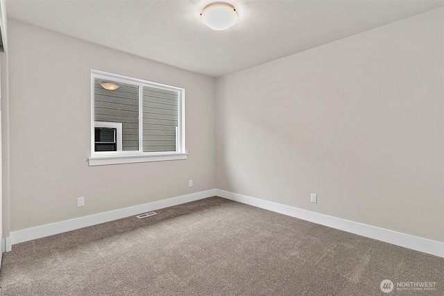 carpeted empty room featuring baseboards and visible vents