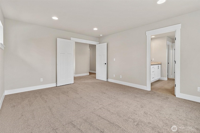 unfurnished bedroom with light carpet, baseboards, ensuite bathroom, and recessed lighting