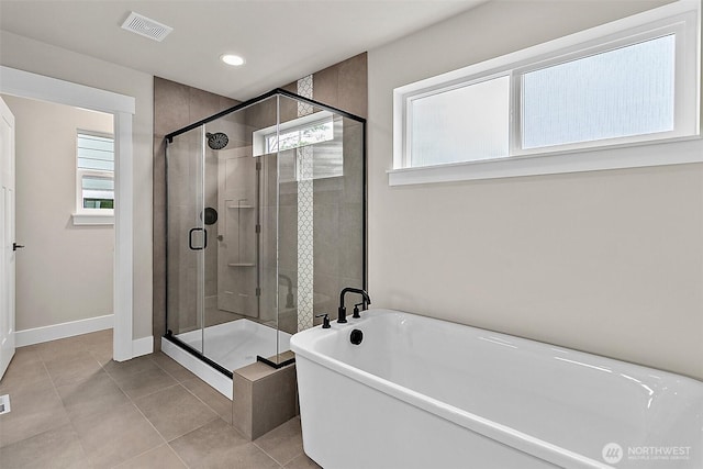 full bath with visible vents, a freestanding bath, a stall shower, baseboards, and tile patterned floors