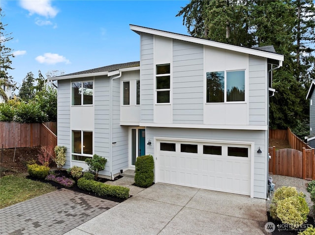 view of front of house with a garage, fence, and driveway