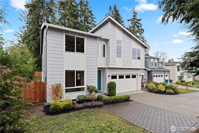 view of front facade with decorative driveway, fence, and an attached garage