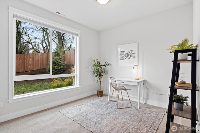 carpeted home office featuring a healthy amount of sunlight, baseboards, and visible vents