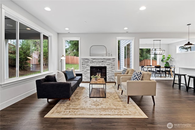 living room featuring a wealth of natural light, dark wood-type flooring, and recessed lighting