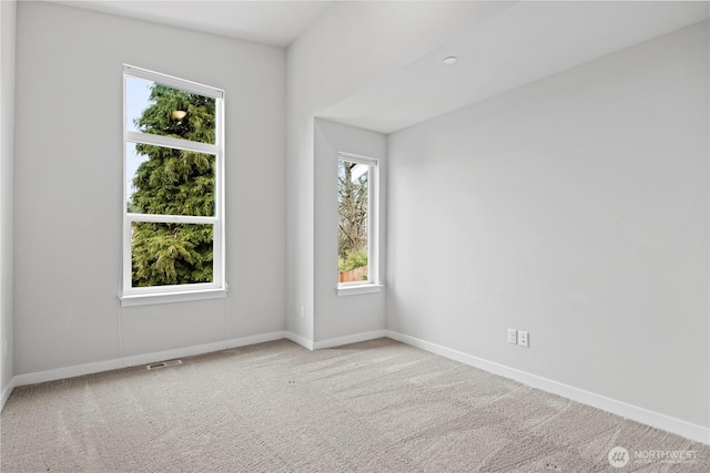 carpeted empty room featuring visible vents and baseboards