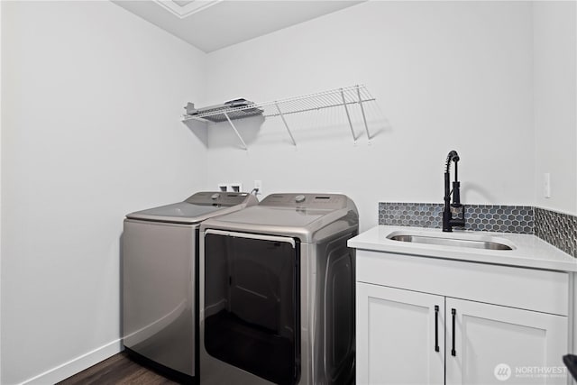 clothes washing area featuring cabinet space, dark wood-type flooring, a sink, independent washer and dryer, and baseboards