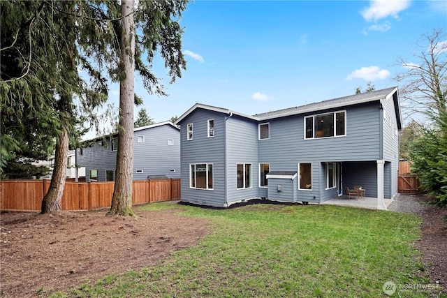 rear view of house featuring a yard, a patio area, and fence