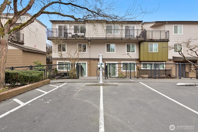 view of property with uncovered parking and fence