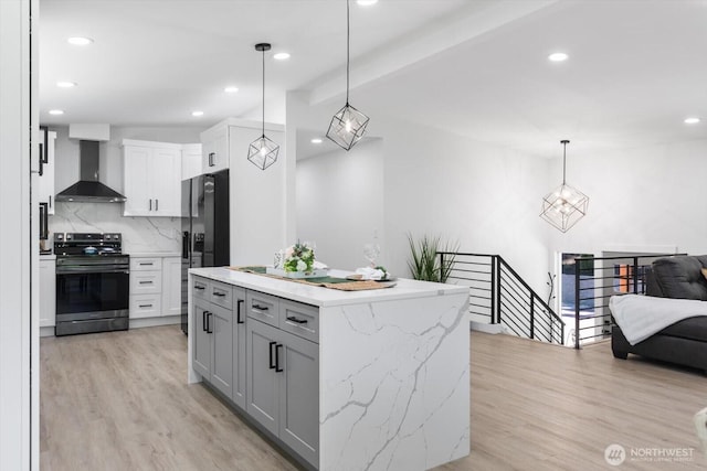 kitchen featuring electric range, light wood-style floors, open floor plan, wall chimney range hood, and backsplash