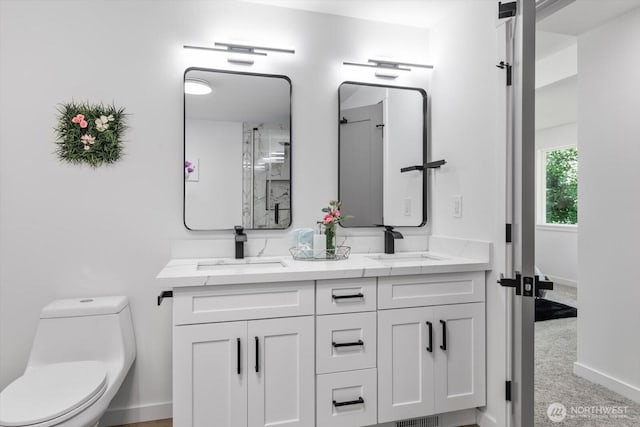 full bathroom featuring baseboards, a sink, toilet, and double vanity