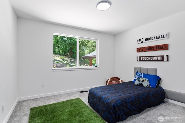 carpeted bedroom featuring visible vents and baseboards