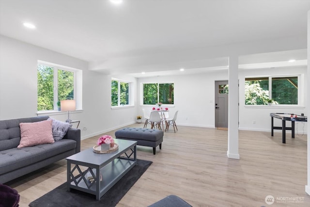 living room featuring light wood-type flooring, baseboards, and recessed lighting