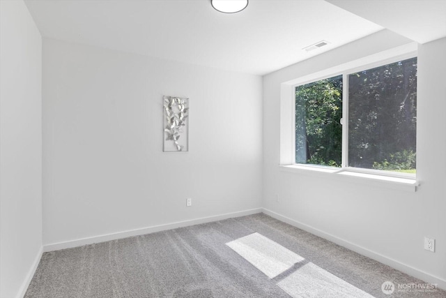 unfurnished room with carpet flooring, visible vents, and baseboards