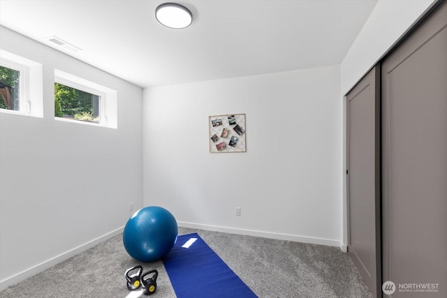 workout room with baseboards, visible vents, and carpet flooring