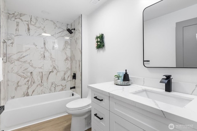 full bath featuring vanity,  shower combination, wood finished floors, and toilet