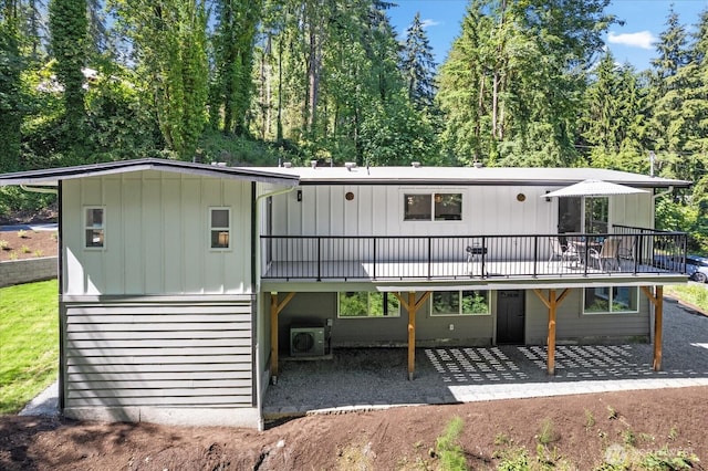 back of property with a deck and a patio