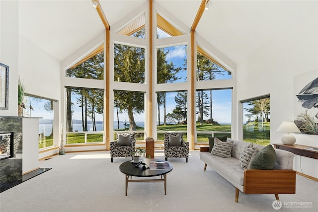 sunroom with a wealth of natural light, vaulted ceiling, and a tiled fireplace