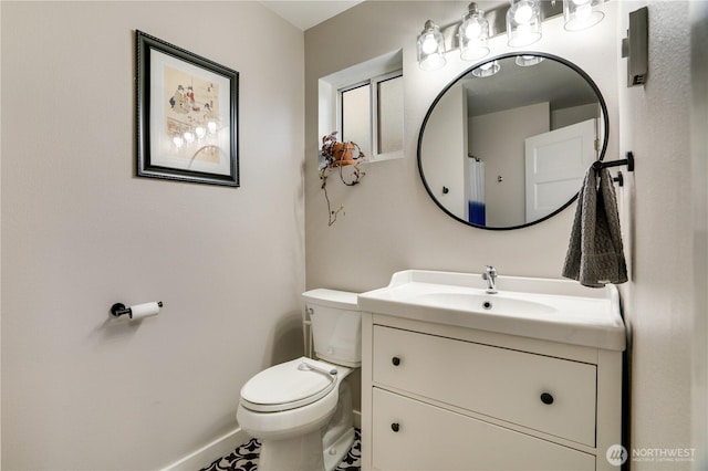 bathroom featuring baseboards, toilet, and vanity