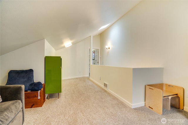 sitting room with vaulted ceiling, baseboards, visible vents, and carpet floors