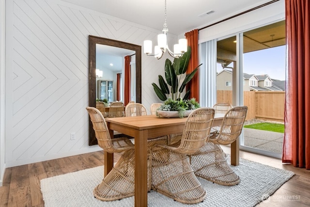 dining room with visible vents, a notable chandelier, and wood finished floors