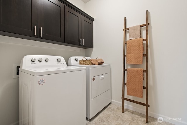 clothes washing area with washer and clothes dryer, cabinet space, and baseboards