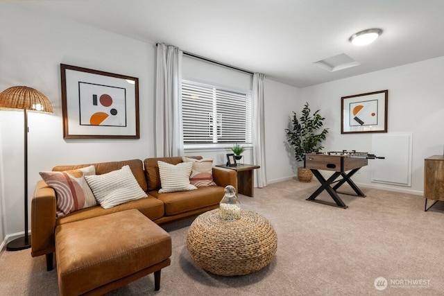 living area featuring light carpet, attic access, and baseboards