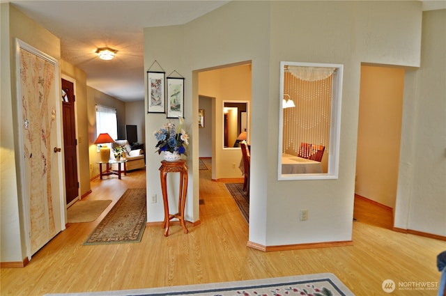 corridor featuring wood finished floors and baseboards