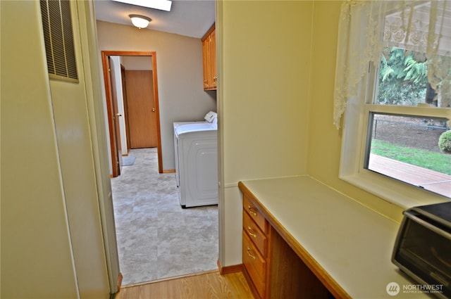 washroom with washing machine and dryer, cabinet space, visible vents, and light wood finished floors