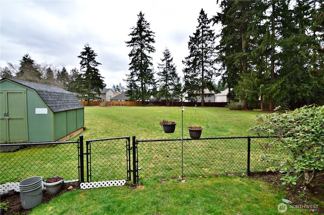 view of yard with a storage shed, an outdoor structure, fence, and a gate