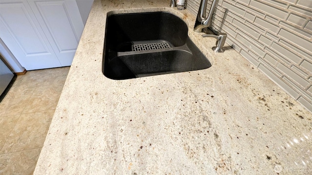 details with light stone countertops and a sink