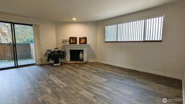 unfurnished living room featuring wood finished floors, recessed lighting, a fireplace, and baseboards