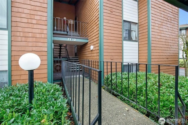 view of home's exterior featuring a balcony and fence