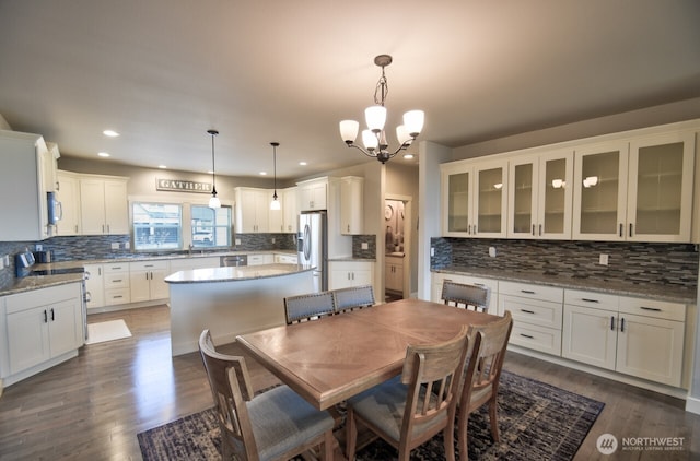 dining space featuring dark wood-type flooring, recessed lighting, and an inviting chandelier