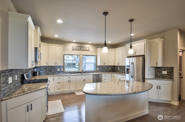 kitchen featuring stainless steel appliances, backsplash, dark wood finished floors, and light stone countertops