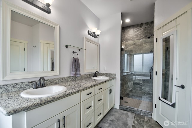 full bath with a stall shower, a sink, and double vanity