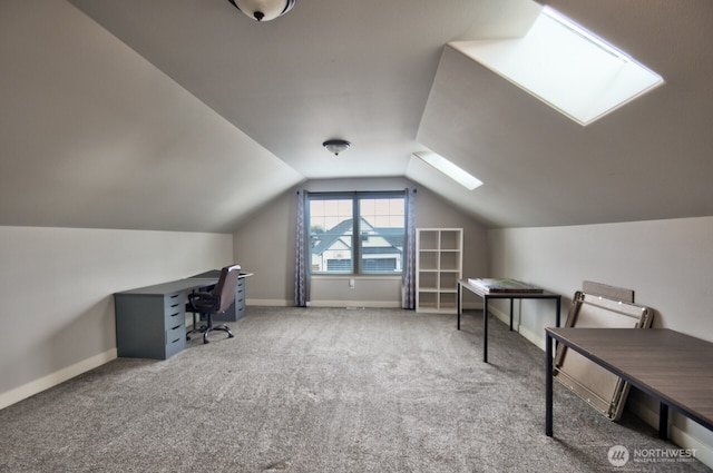 home office with vaulted ceiling with skylight, carpet, and baseboards