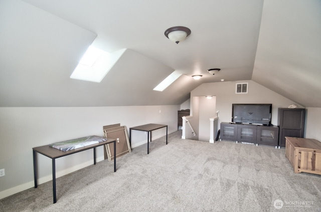 additional living space featuring lofted ceiling with skylight, carpet, and visible vents