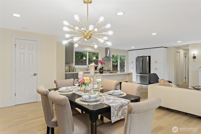 dining area featuring light wood finished floors, recessed lighting, and a notable chandelier