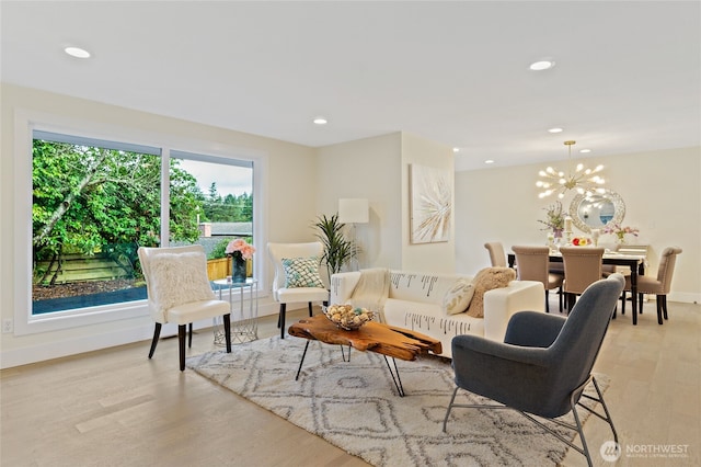 living area featuring baseboards, recessed lighting, light wood-style flooring, and an inviting chandelier