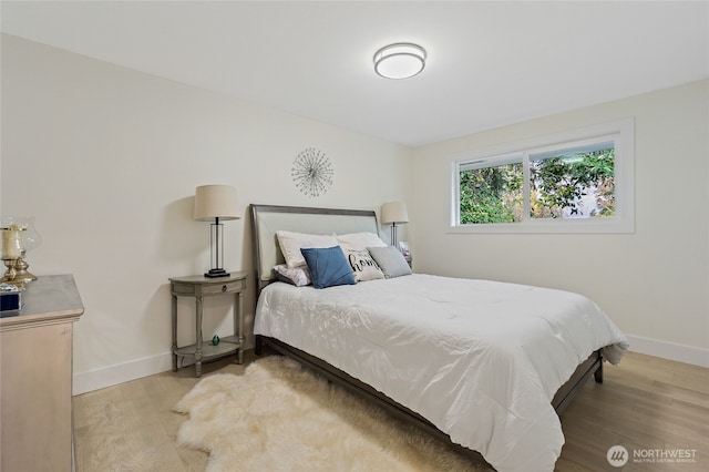 bedroom with baseboards and wood finished floors