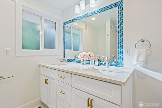 full bathroom featuring walk in shower, visible vents, a sink, and double vanity