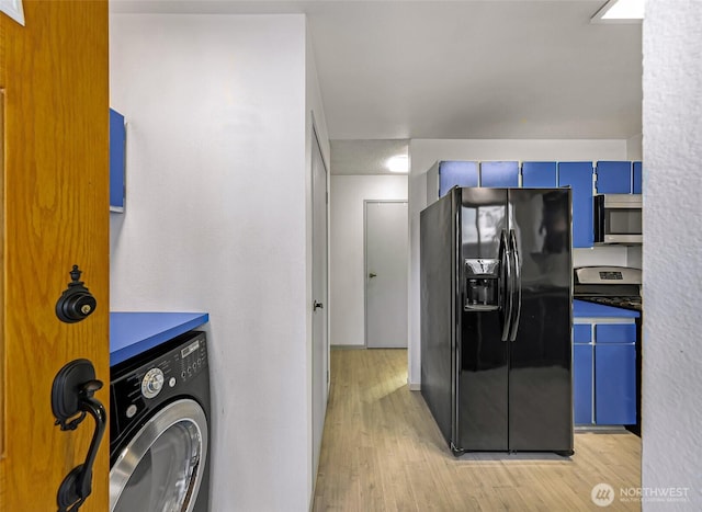 kitchen featuring washer / dryer, blue cabinetry, stainless steel appliances, and light wood finished floors