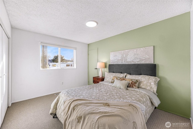 bedroom featuring carpet, baseboards, and a textured ceiling