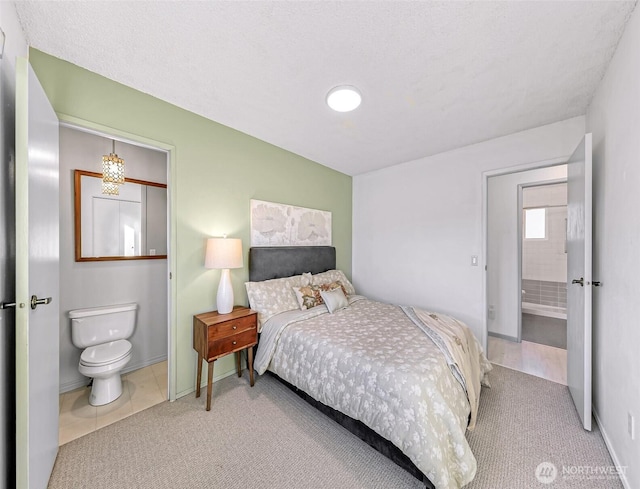 bedroom with carpet floors, connected bathroom, and baseboards