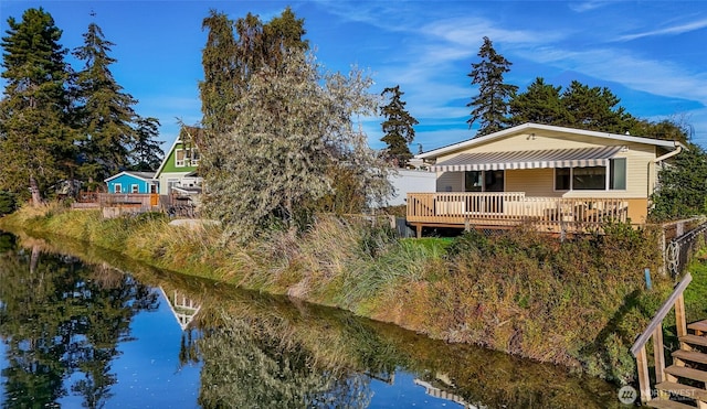 back of property with a deck with water view