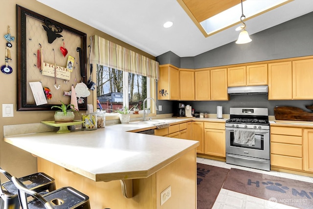 kitchen with stainless steel range with gas stovetop, a sink, under cabinet range hood, and light brown cabinetry