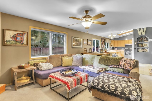 living room with ceiling fan with notable chandelier, vaulted ceiling, a wealth of natural light, and light colored carpet