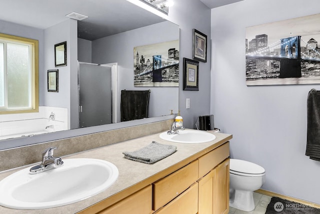 bathroom featuring double vanity, a stall shower, a sink, and visible vents