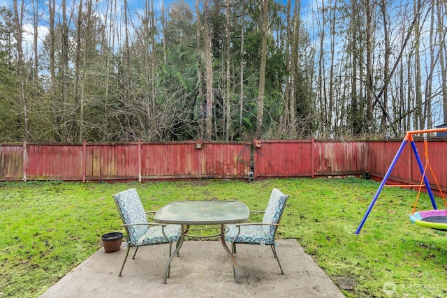 view of yard featuring outdoor dining space, a playground, a patio, and a fenced backyard