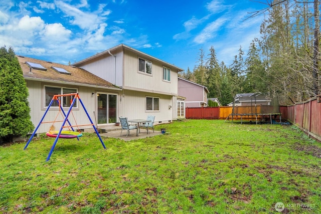 rear view of house featuring a fenced backyard, a trampoline, a lawn, and a patio