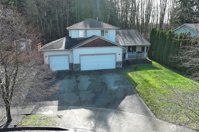 view of front of home with driveway, stone siding, a porch, an attached garage, and a front lawn